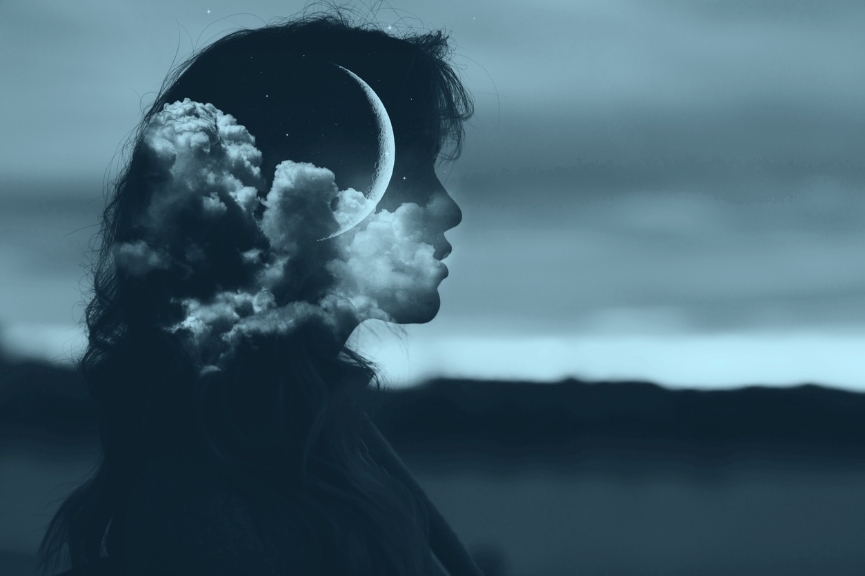 A silhouette of a woman with a moon and clouds in her head to represent dream enhancement and targeted memory reactivation features in SleepSpace.
